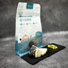 Patagonian Toothfish in 50g portion on slate with lemon slices and herbs, and packaging at background in Singapore.