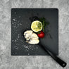 Japanese Oyster meat on spoon and slate with lemon slice and herbs in Singapore (flatlay).