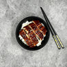 Unagi Kabayaki 150g topped with sesame seeds on a bowl of Japanese rice and a pair of chopsticks in Singapore.