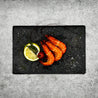 Cooked Vannamei Prawn on slate with lemon slices and herbs in Singapore (flatlay).