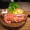 Cooked Argentine Red Shrimp on wooden board with fries and sauce